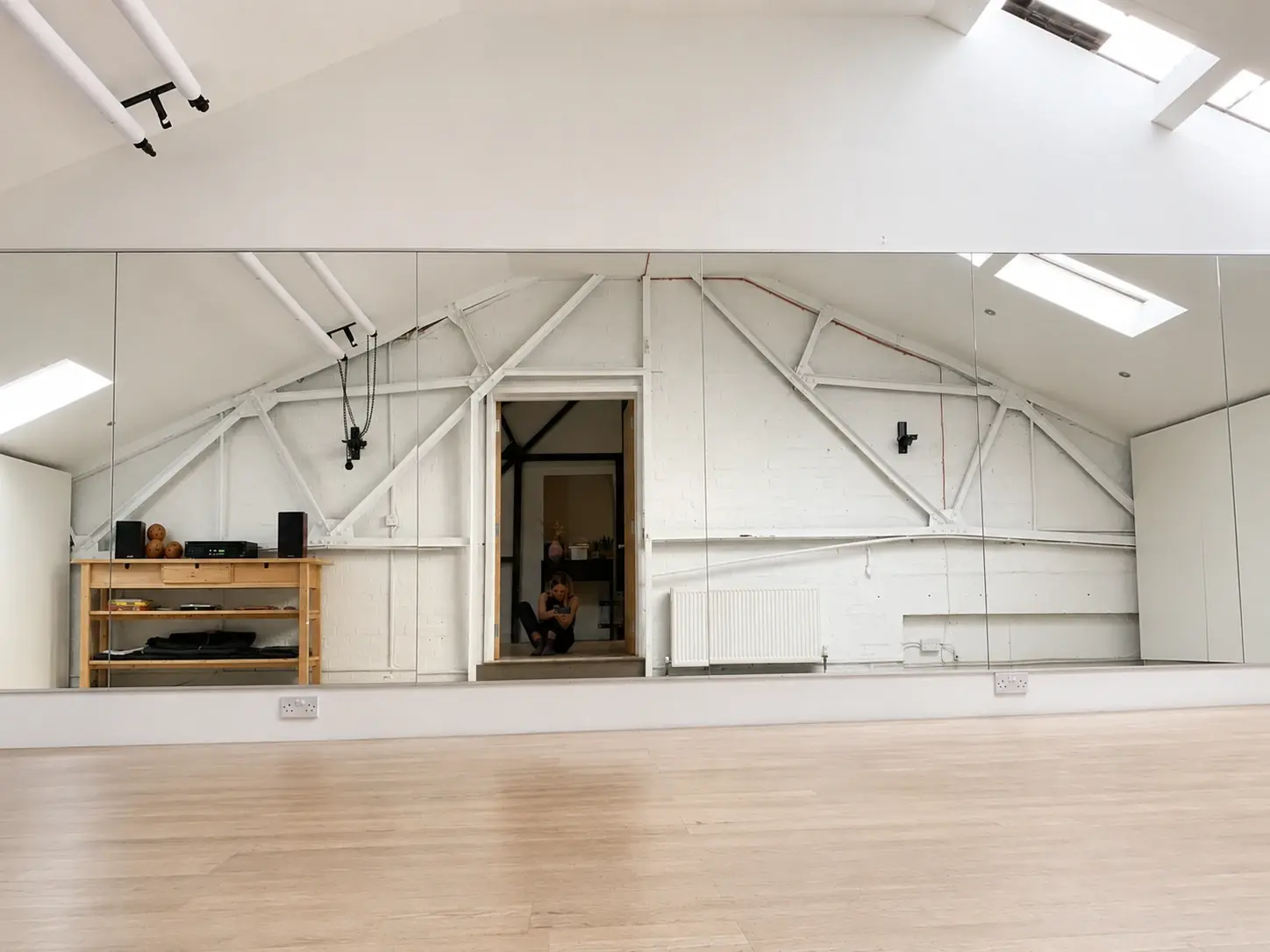 Studio 28 from the front door: timber floor stretching to the mirrors